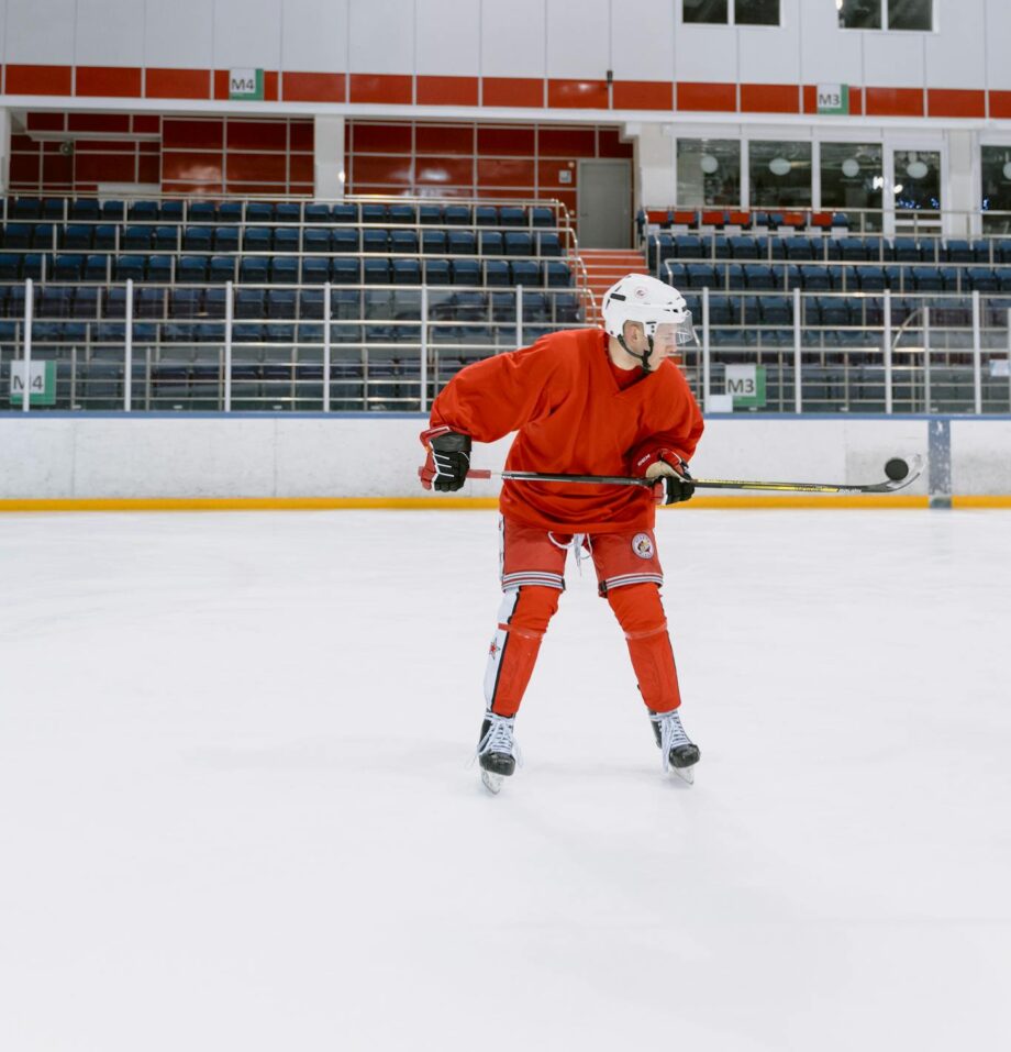 Hockey player practicing on indoor ice rink in full gear.
