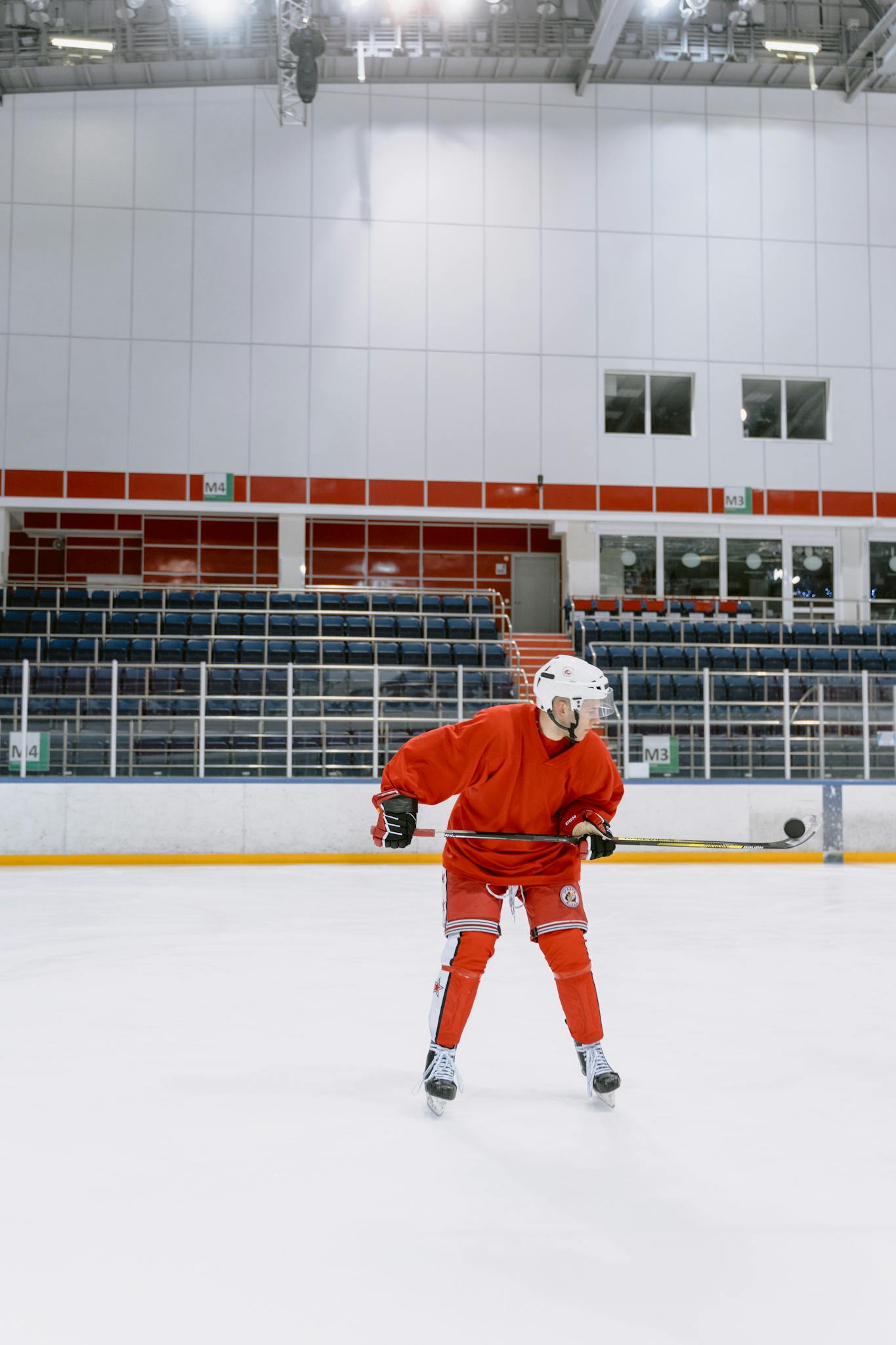 Hockey player practicing on indoor ice rink in full gear.